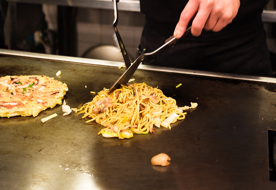Osaka-style okonomiyaki - a savoury Japanese pancake with noodles, egg, cabbage, meat and seafood.