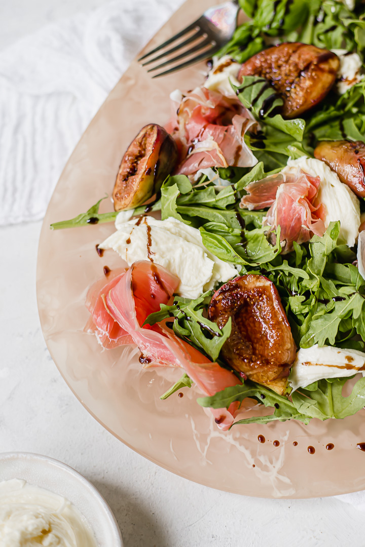 Warm figs on a bed of rocket, prosciutto and torn mozzarella
