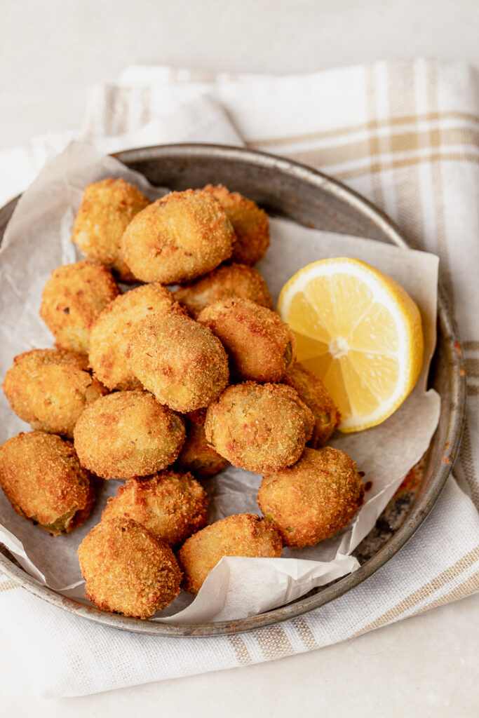 A plate of fried olives with a breadcrumb coating