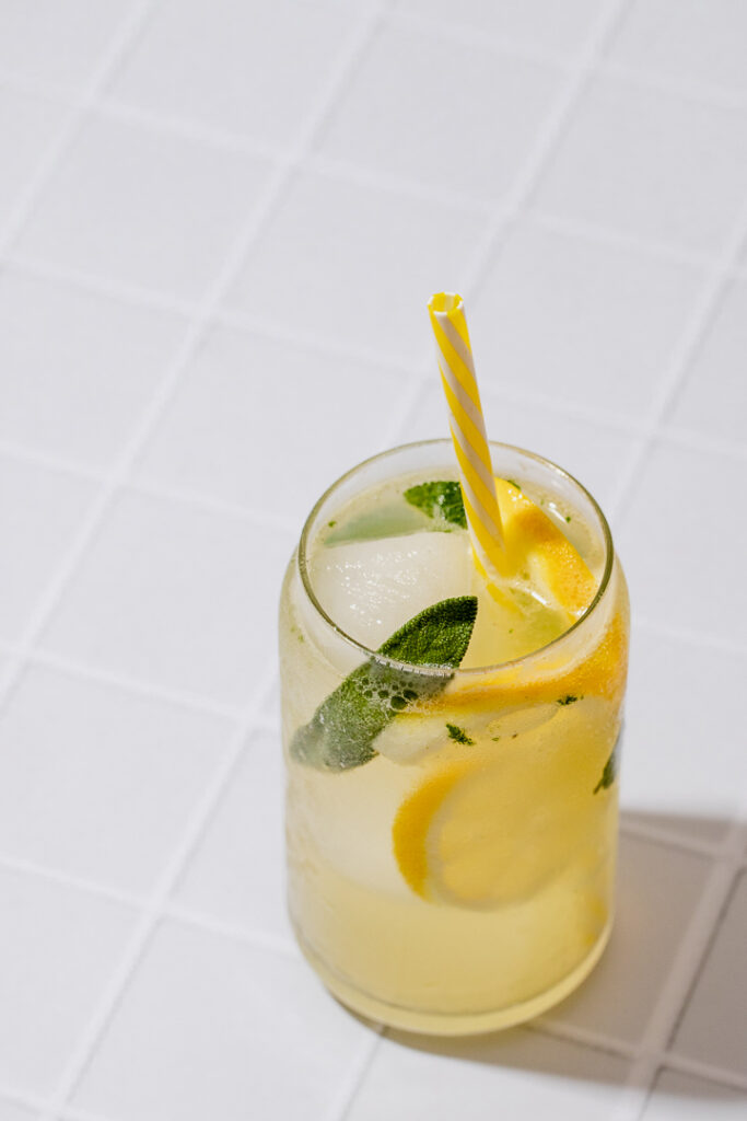 A glass of lemonade with lemon and sage
