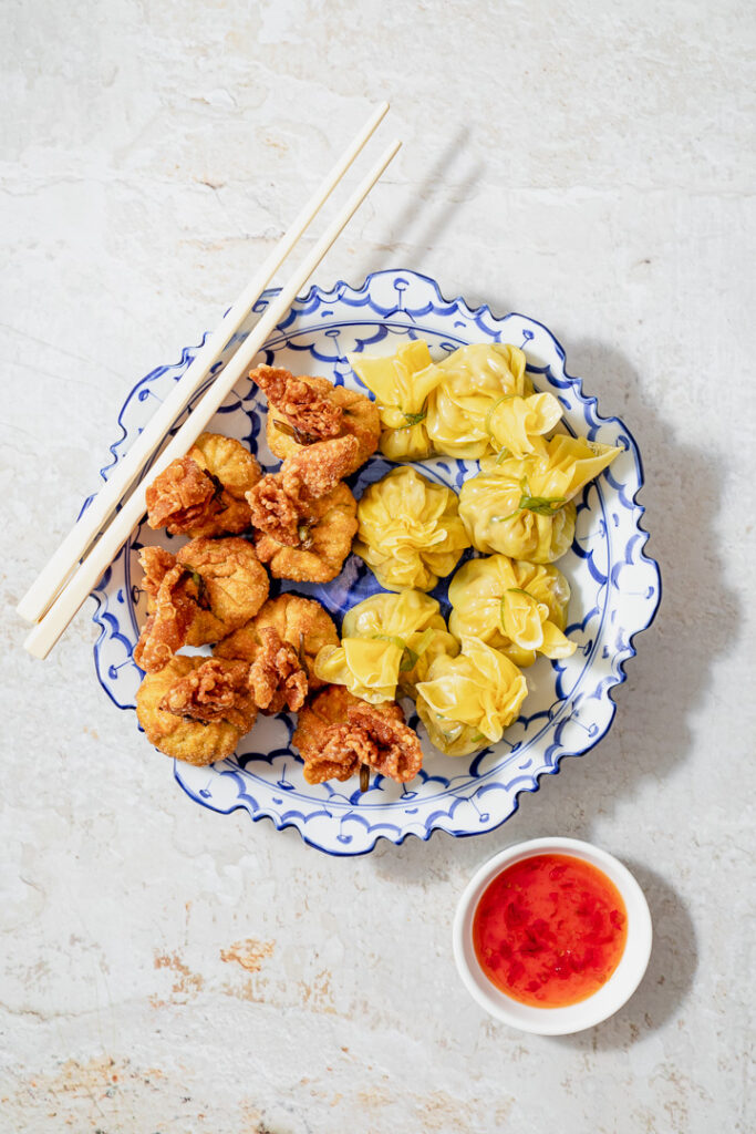A blue plate with fried and steamed money bag dumplings