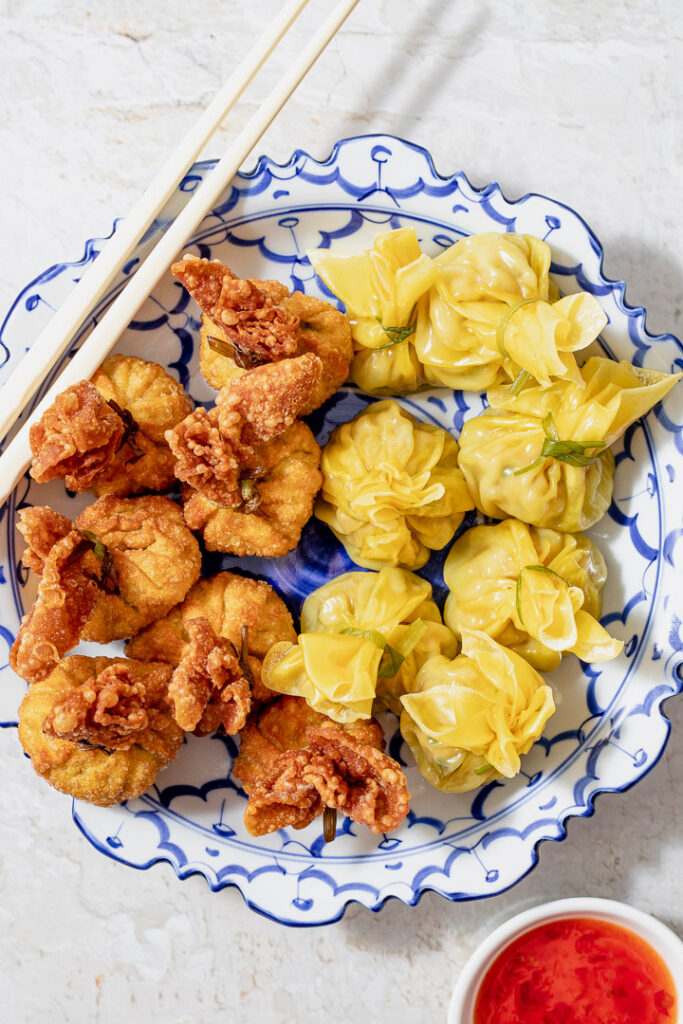 A blue plate with fried and steamed money bag dumplings