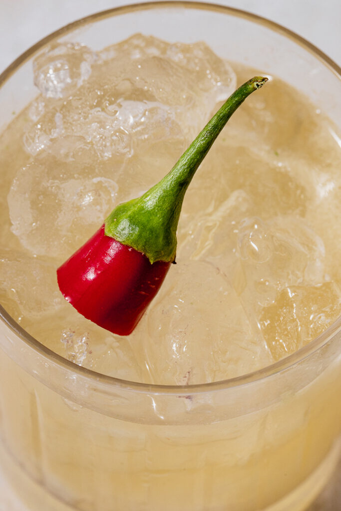 Close up of a picante de la casa cocktail with a chilli on top