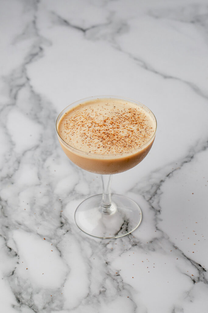 Brandy Alexander cocktail in a coupe on a marble bench