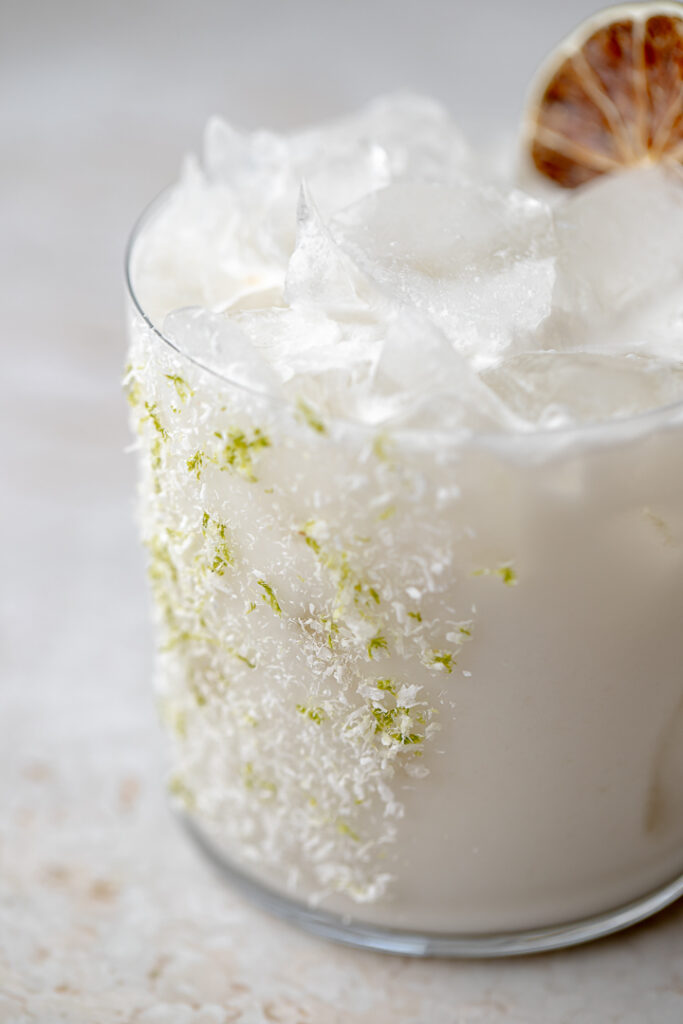 Close up of the salt, desiccated coconut and lime zest used to rim the drink.