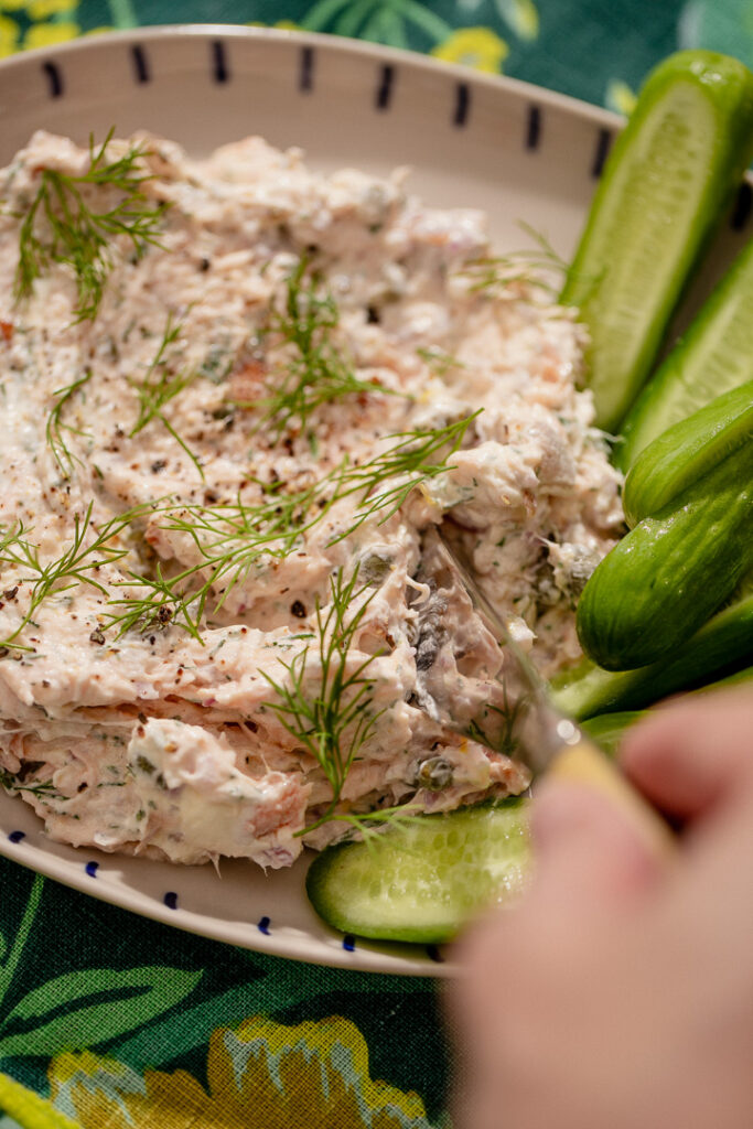 A small knife scooping into smoked salmon dip.